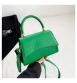 Detalle del bolso verde textura cocodrilo con asa trenzada y pequeño monedero colgante - Verde