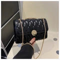 Detail of black quilted chain bag with shiny finish and round golden metal clasp - Black