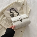 Elegant white quilted chain crossbody bag with metallic clasp on cream blazer - White