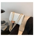Detailed side view of white quilted crossbody bag with gold chain and metal twist lock - White