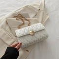 White quilted chain bag with wavy texture and golden buckle on a beige blazer - White