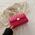 Hot pink quilted chain crossbody bag with gold buckle on a stylish white suit jacket - Rose Red