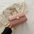Sac à chaîne matelassé rose pâle avec boucle dorée sur un blazer texturé - Rose
