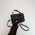 Elegante schwarze Umhängetasche aus Leder mit goldener Hardware und Tragegriff oben - Schwarz