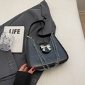 Minimalist black hobo shoulder bag with silver bow accent and chain straps for women - Black