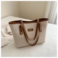 Détail du sac cabas en paille tissée avec poignées en cuir et plaque de marque - Marron