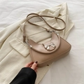 Borsa a mezzaluna beige con fiocco argento e tracolla sottile su un blazer morbido - Cachi