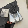 Chic silver metallic crescent underarm bag featuring a delicate bow and chain detail - Silver