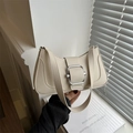 Bolso de hombro crema minimalista con hebilla plateada grande sobre alféizar de ventana - Blanco