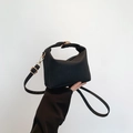 Fashionable black textured handbag with woven pattern and gold hardware on minimalist background - Black