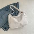 Beige corduroy crossbody bag with cute cloud charm on blue denim jacket background - White