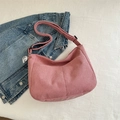 Pink corduroy crescent shoulder bag with cute puppy charm on blue denim background - Pink
