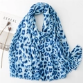 Close-up of blue leopard print scarf with fringed edges on minimalist white background - Blue