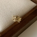 Close-up of gold geometric multilayer ear cuff with zircons on a rustic linen background - Gold