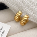 Orecchini a cerchio intrecciati in oro opaco stile vintage su sfondo in maglia bianca - Oro Opaco