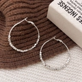 Silver hoop earrings with square beads decoration on textured knitted background - Silver