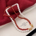 Detail of red agate and pearl necklace with sparkling gold infinity buckle design - Red Agate and White Pearl Style