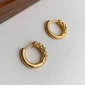 Primer plano de pendientes de aro dorados con superficie pulida y relieve de espiga - Dorado