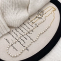 Close-up of pearl necklace with gold chain and adjustable slider clasp on elegant tray - White Pearl Necklace