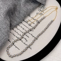 Detail of grey pearl necklace with golden spacer beads on a soft knit background - Gray Pearl Necklace