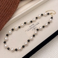 Detailed close-up of tiger eye stone and pearl beaded necklace with golden lobster clasp - French Pearl Black Bead Color Block Beaded Necklace (b-458)