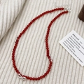Red agate beaded necklace with silver bow pendants on a cozy knit background - Red Agate Bow Necklace