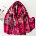 Detalle de bufanda fucsia con diseño geométrico y bordes de flecos finos en estilo zen - Rosa Rojo