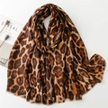 Detail shot of leopard print scarf with frayed edges styled with a magazine and dried flowers - Caramel Leopard
