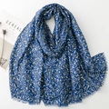 Blue cotton linen scarf with gold leaf print and frayed edges displayed with magazine - Blue (SL2311-006)