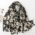 Cotton linen feel scarf featuring large black floral prints and decorative long tassels - Black & White
