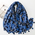 Detail of dark blue floral cotton scarf with fringe tassels on white background - Blue