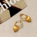 Detail of matte gold heart earrings featuring polished hoops on a fashion backdrop - Gold Heart Pendant Hoop Earrings
