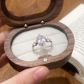 Sparkling oval zircon ring with side stones in a walnut wood jewelry gift box - Silver