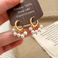 Elegante goldene Kupferohrringe mit fünf weißen Perlenanhängern für Damen Mode - Goldene Perlenohrringe / Gold