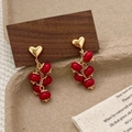 Retro grape cluster earrings with red glass beads and gold heart studs on wood surface - Burgundy