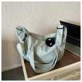 Detail of mint green crossbody bag with round pouch and black plush pendant charm - With Pendant / Green