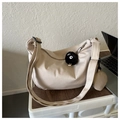 Detail of beige crescent crossbody bag with ribbed fabric texture and plush charm - With Pendant / Khaki