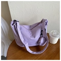 Detail of purple nylon dumpling bag showing textured fabric and round coin purse attachment - Purple