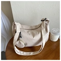 Macro detail of beige nylon crossbody bag texture with wide strap and round coin purse - Khaki