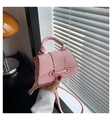 Dettaglio ravvicinato della pelle grana litchi rosa e cuciture su questa mini borsa - Rosa