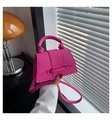 Dettaglio della borsa in pelle litchi rosa acceso con forma a trapezio e manico superiore - Rosa Rosso
