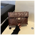 Detail van donkerbruine gewatteerde crossbodytas met goudkleurig slot en schakelketting - koffiekleur