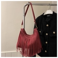 Detalle de bolso burdeos con flecos en acabado de ante y herrajes metálicos dorados - Rojo