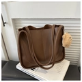 Detalle de bolso tote de cuero marrón oscuro con asas gruesas y colgante de osito - Con Colgante / café