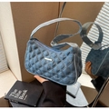 Close-up of denim shoulder bag with quilted diamond pattern and gold metal hardware - Light Blue