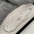 Collana classica a doppio strato con perle bianche esposta su un portagioie elegante - Stile Perla 10mm+4mm