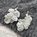 Elegant silver petal tassel earrings with white pearls on dark knit background - Petal Earrings
