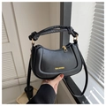 Detalle de bolso hobo negro de media luna con asa anudada y logo dorado junto a la ventana - Negro