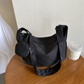 Minimalist black crescent crossbody bag with a round coin purse on a wooden table - No Pendant / Black
