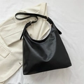 Grand sac hobo noir à boucle dorée réglable posé sur un blazer beige élégant - Noir